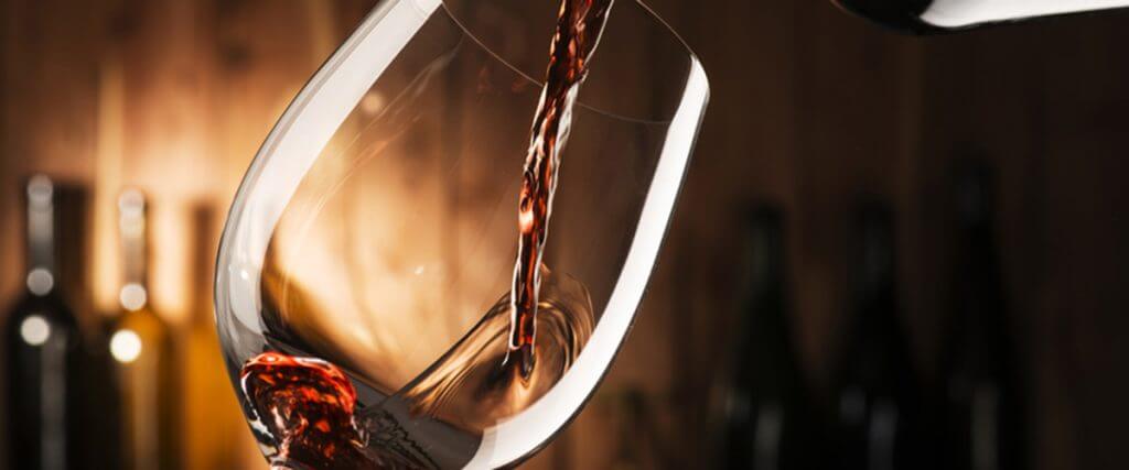 Rotwein wird in Glas gegossen